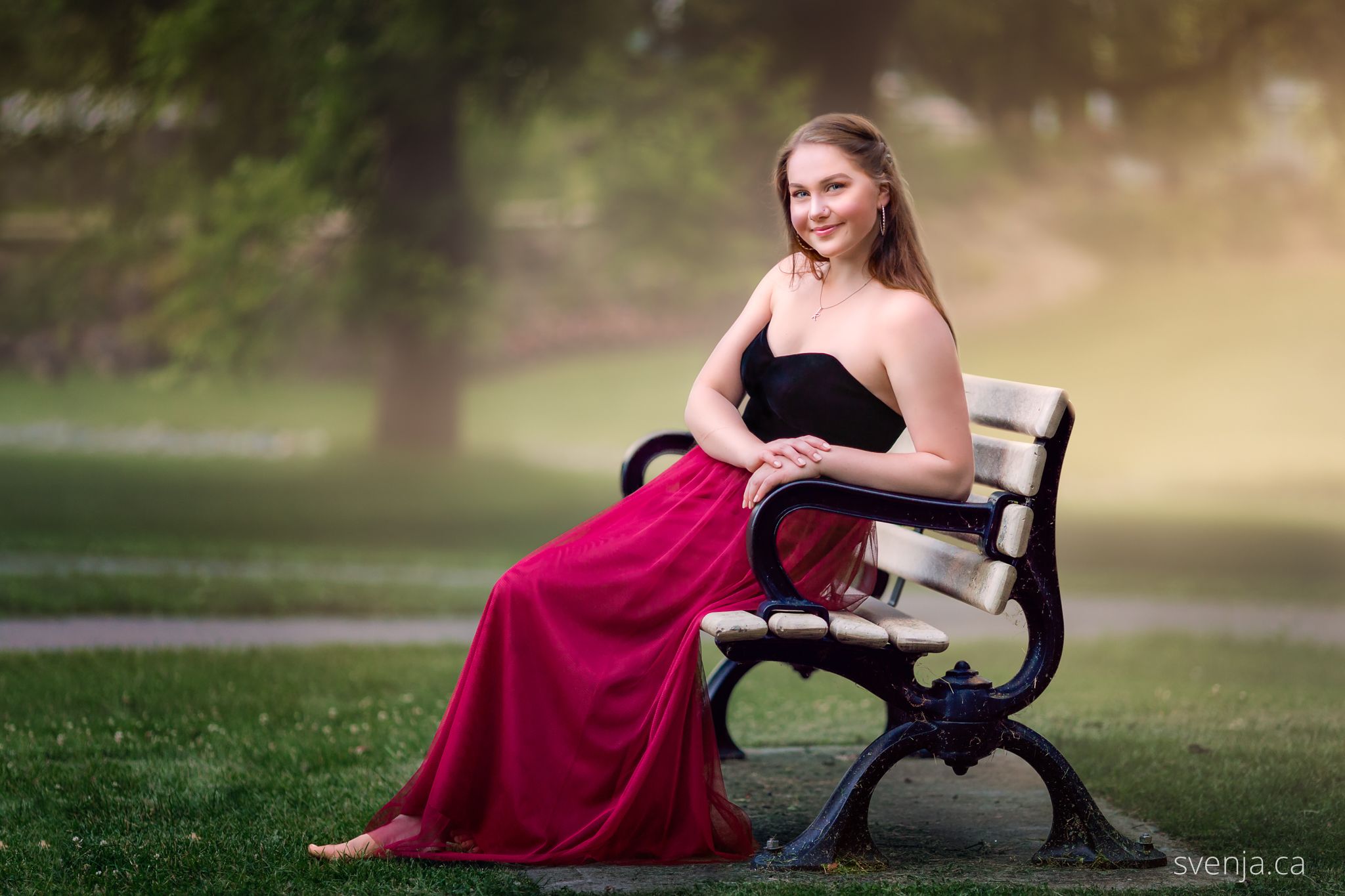 teenage girl in prom dress sitting on a bench