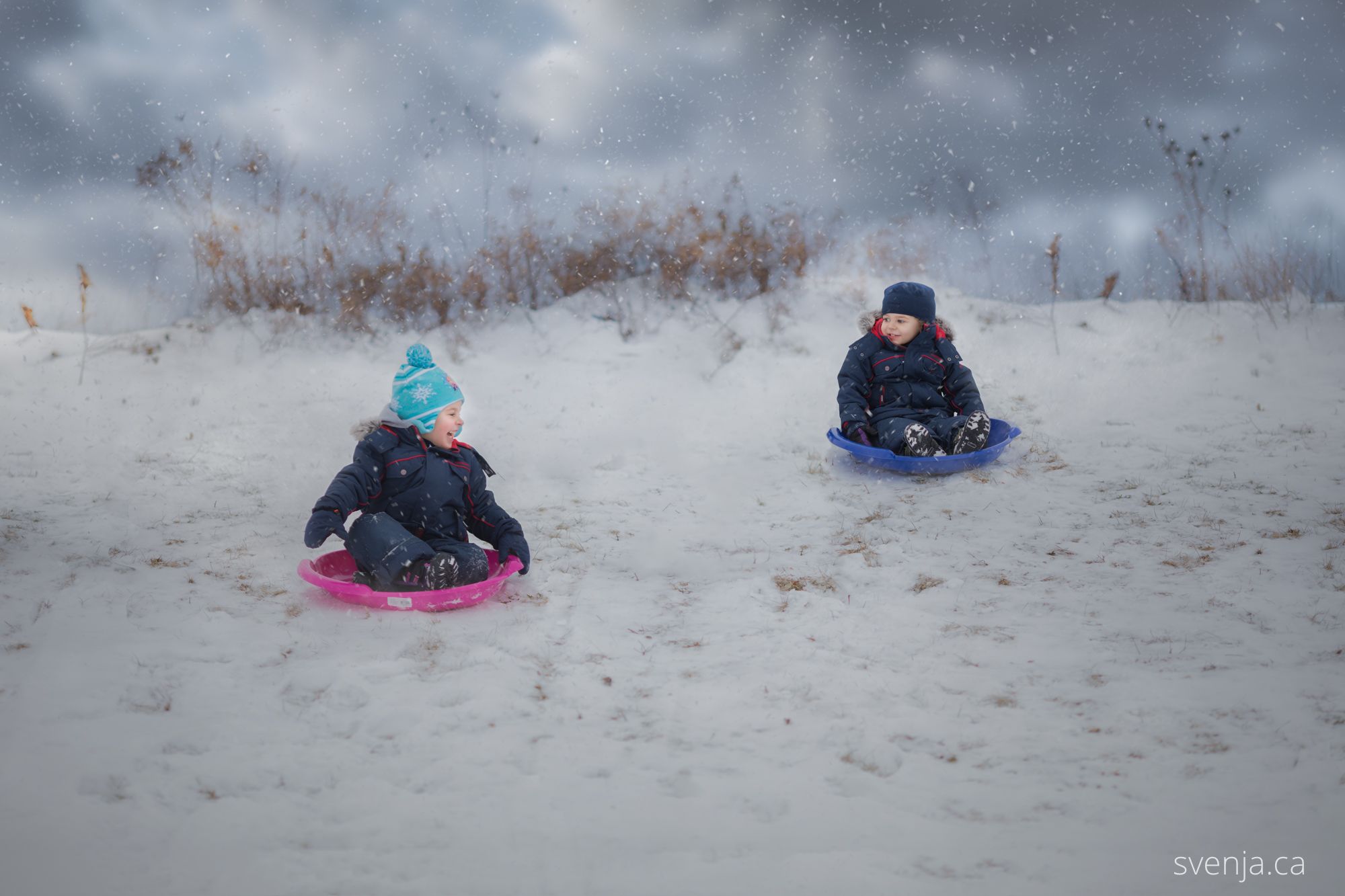 mother prepares her two children for sledding down a hill