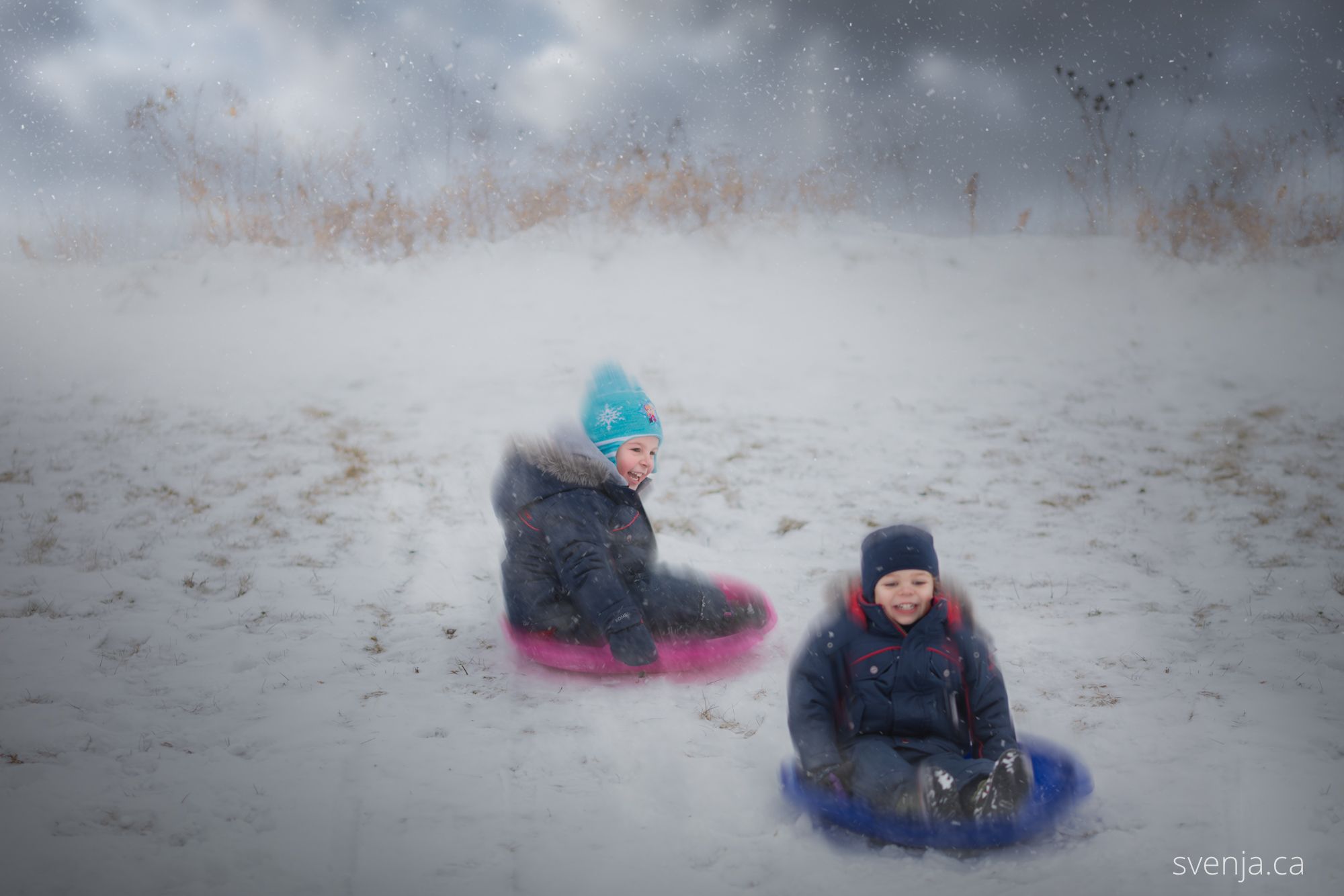 mother prepares her two children for sledding down a hill