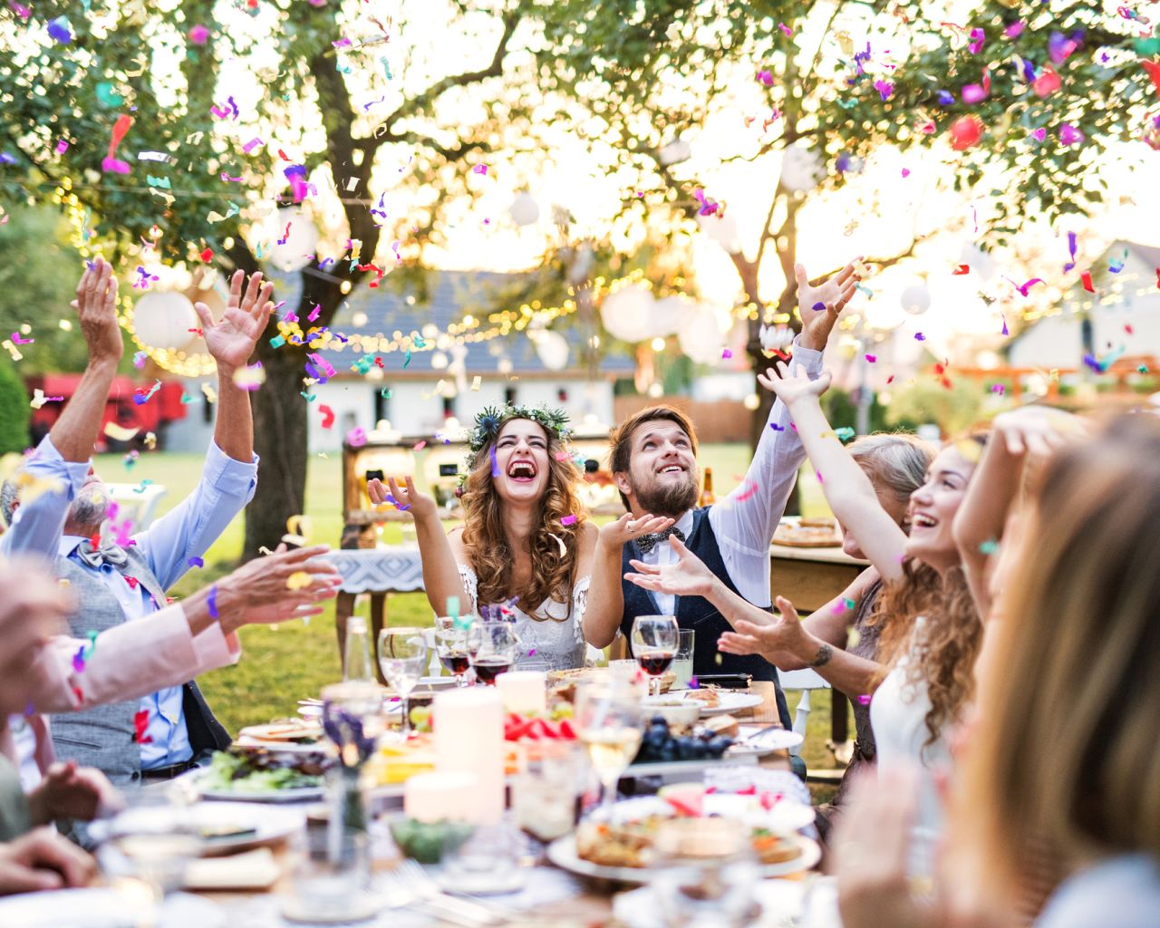 Bride and groom with guests at wedding reception outside in the backyard. Goedkoop trouwen tips