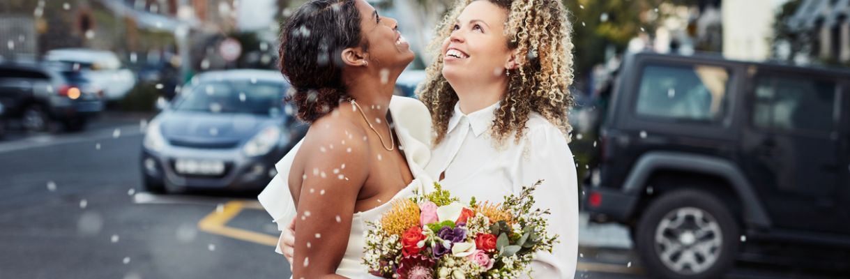 Shot of a young lesbian couple standing outside together and celebrating their wedding lhbti-bruiloft-gay-marriage-ideeen