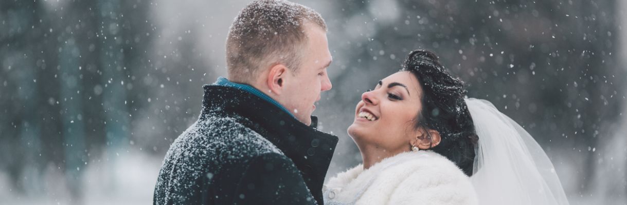 Bride and groom walking in the city winter-bruiloft-bruidspaar-in-sneeuw