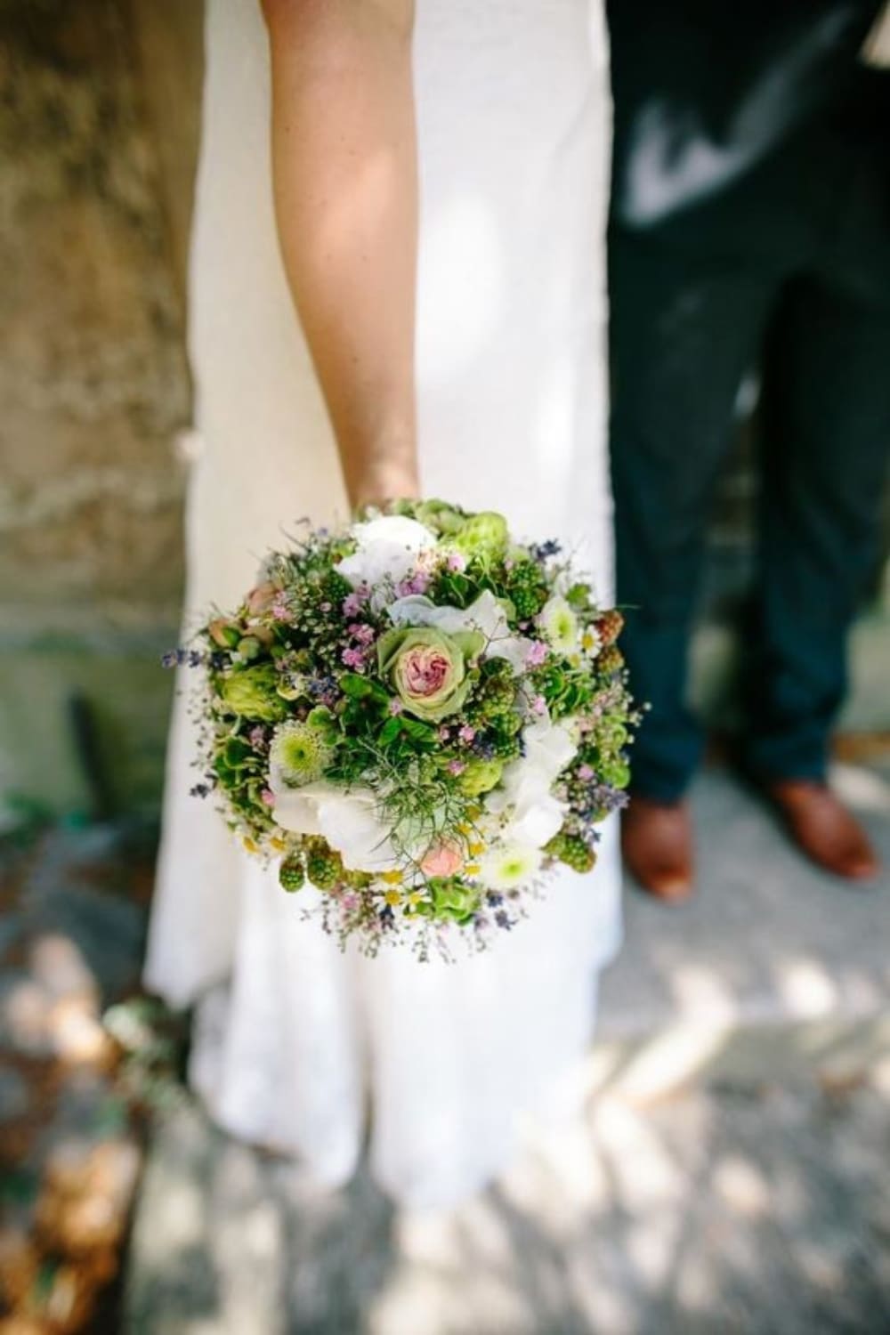 bruid-met-trouwboeket-veldbloemen-rond-met-groene-kleur