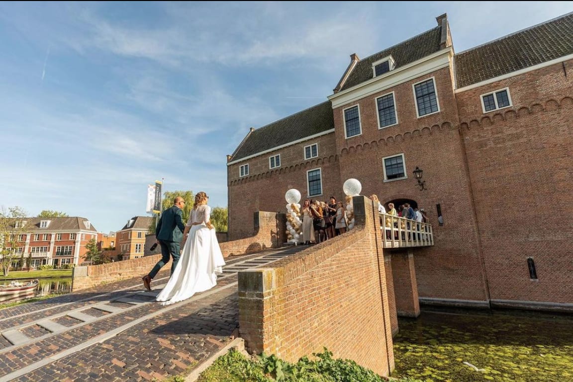 bruidspaar-op-brug-naar-trouwlocatie-kasteel-woerden