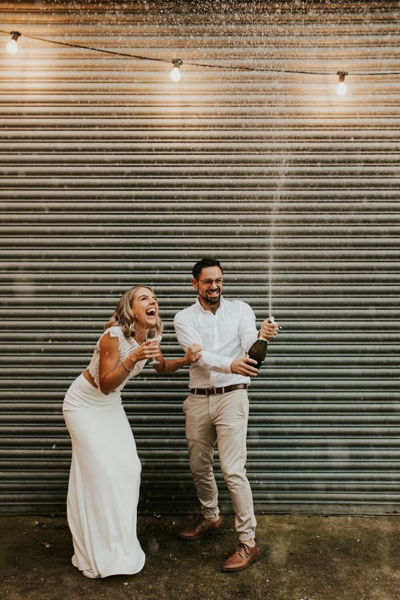lachend-bruidspaar-ontkurkt-champagnefles