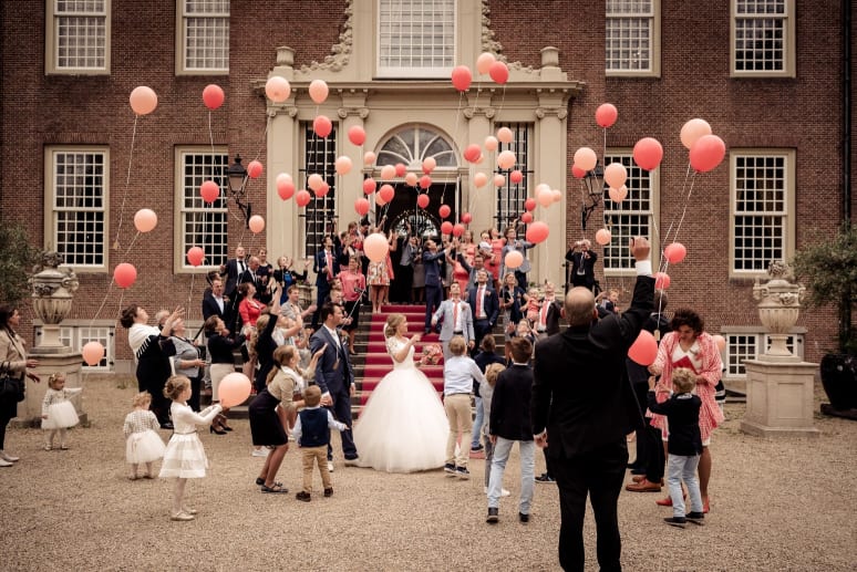 bruiloftgezelschap-op-bordes-met-ballonnen-bij-trouwlocatie-slot-zeist