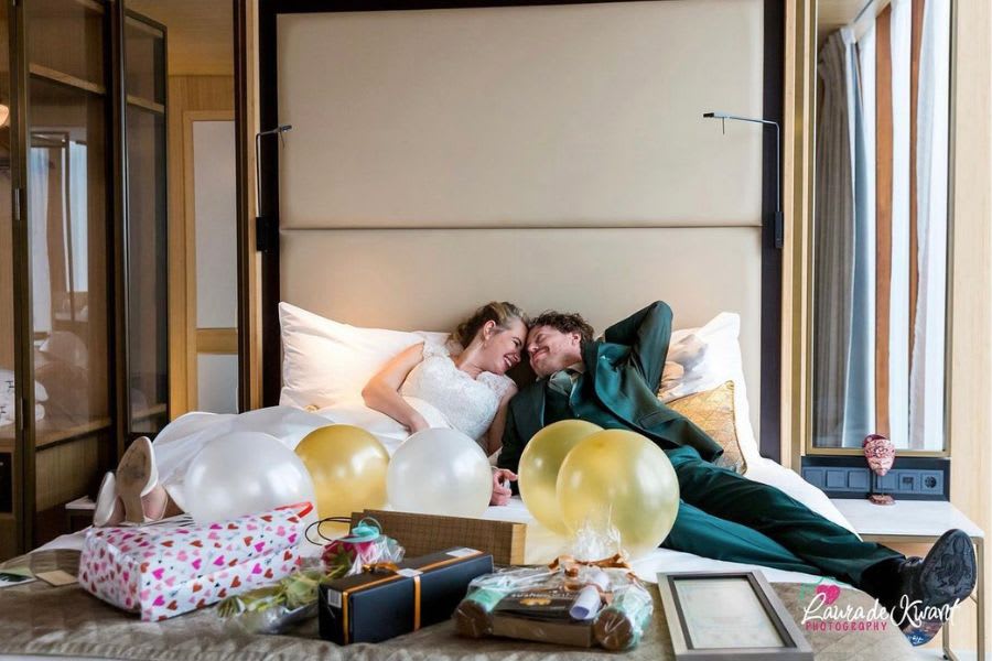 bruidssuite-in-hotel-bruidspaar-op-bed-met-ballonnen-en-cadeaus