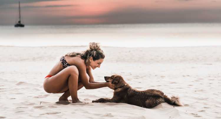 Chica con su perro en la playa