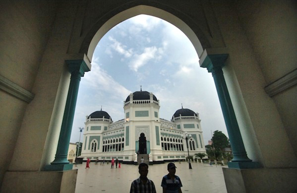 Warga beraktivitas di sekitar Masjid Raya Medan atau Masjid Raya Al Mashun di Medan, Sumut, Jumat (28/6). Objek sejarah yang dibangun pada pemerintahan Sultan Ma'moen al Rasyid Perkasa Alamsyah IX dari Kesultanan Deli itu menggunakan gaya arsitektur perpaduan Timur Tengah, India dan Eropa yang kini memasuki usia 107 tahun. ANTARA FOTO/Iggoy el Fitra/ss/Spt/13