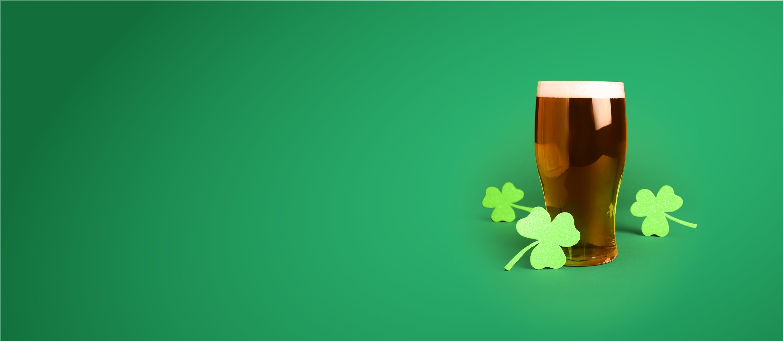 Paper shamrocks around a pint of beer for Confetti's Virtual Irish Beer Tasting with Beer Tasting Set