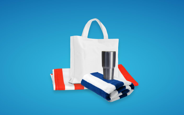 A tote bag, silver tumbler, and pool towels for Confetti's Summer Gift Basket