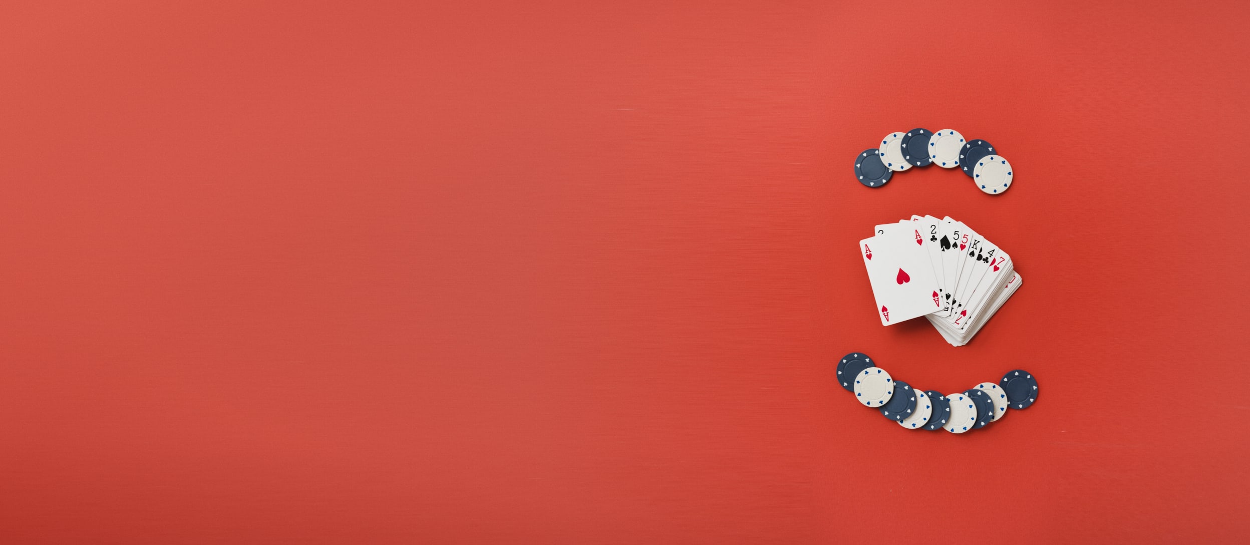 Two stacks of poker chips and a deck of cards spread out on a table for Confetti's Virtual Online Poker for Team Building