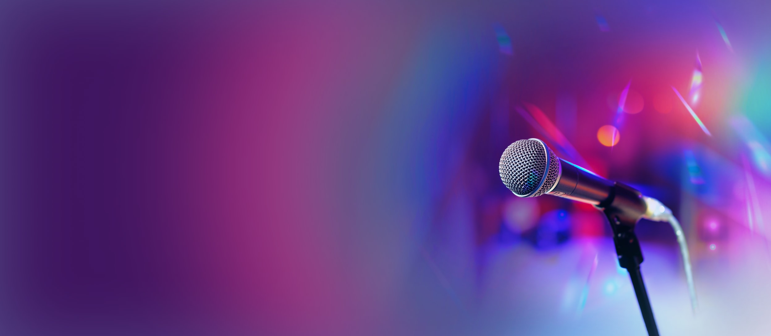 A microphone in front of colorful concert lights for Confetti's Virtual Bar