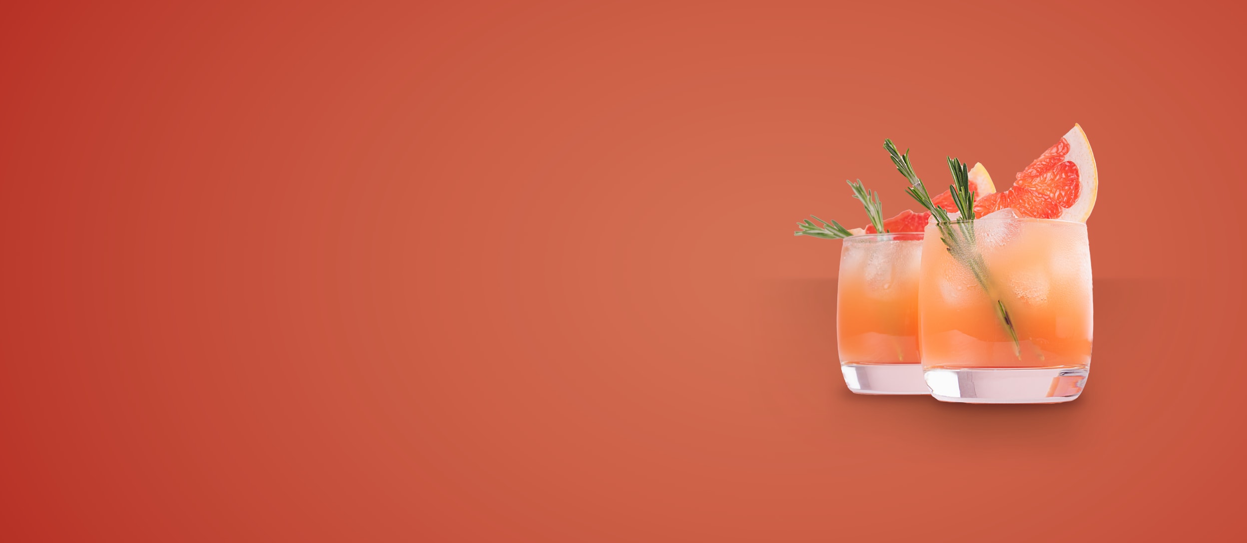 Two glasses of a grapefruit mocktail with sprigs of rosemary for Confetti's Virtual Mocktail Gift Set