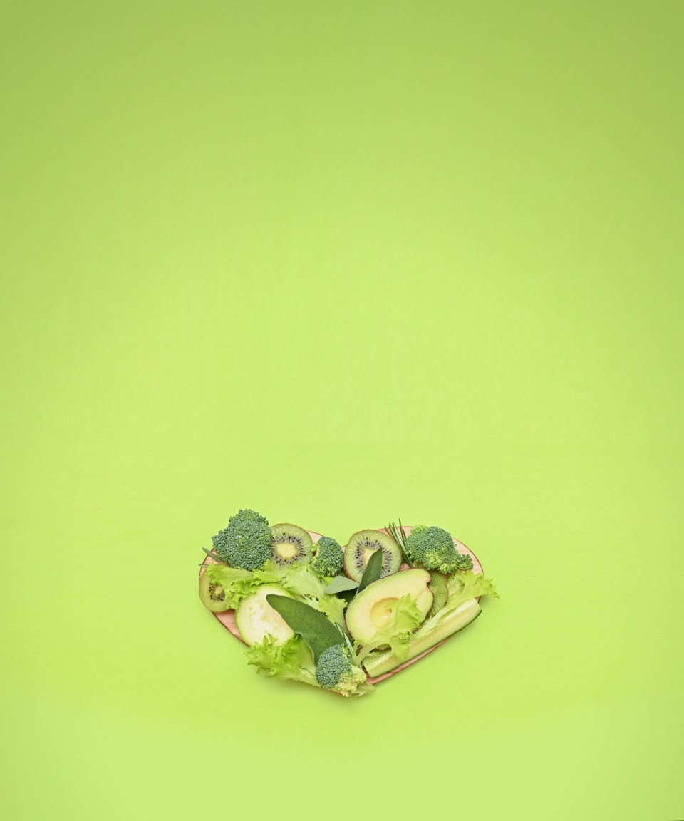 Green fruits and vegetables on a heart-shaped cutting board (small)