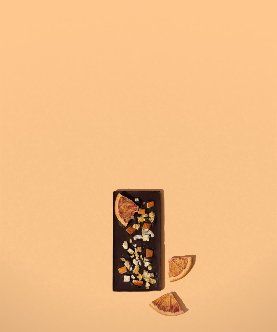 A chocolate bar topped with chopped nuts and dried oranges for Confetti's Virtual Chocolate Bar Making Class 