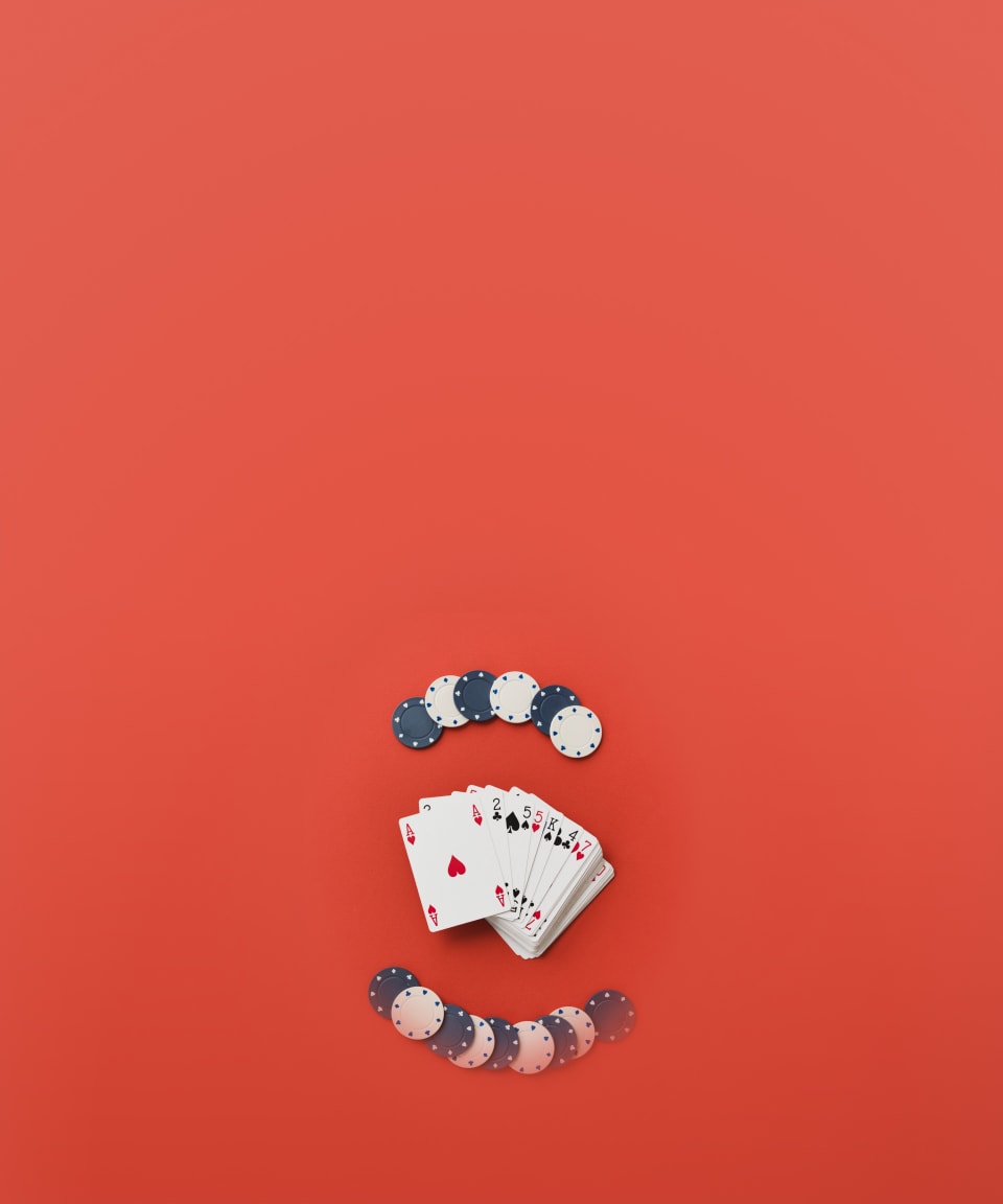 Two stacks of poker chips and a deck of cards spread out on a table for Confetti's Virtual Texas Hold 'Em