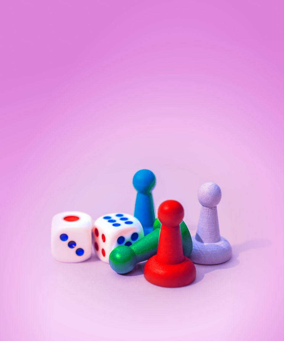 Colorful dice and board game pawns for Confetti's Virtual Game Night