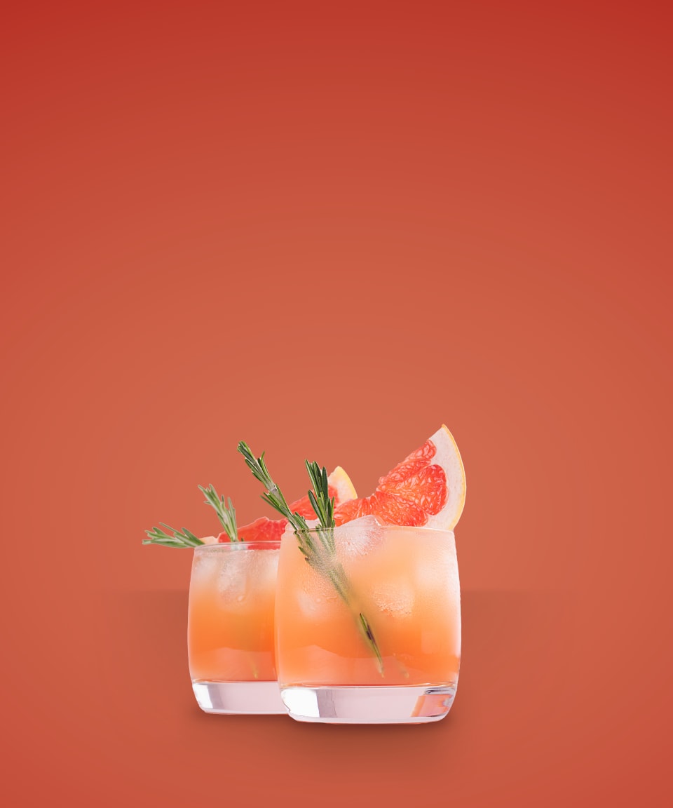 Two glasses of a grapefruit mocktail with sprigs of rosemary for Confetti's Virtual Mix it Yourself Mocktail Box