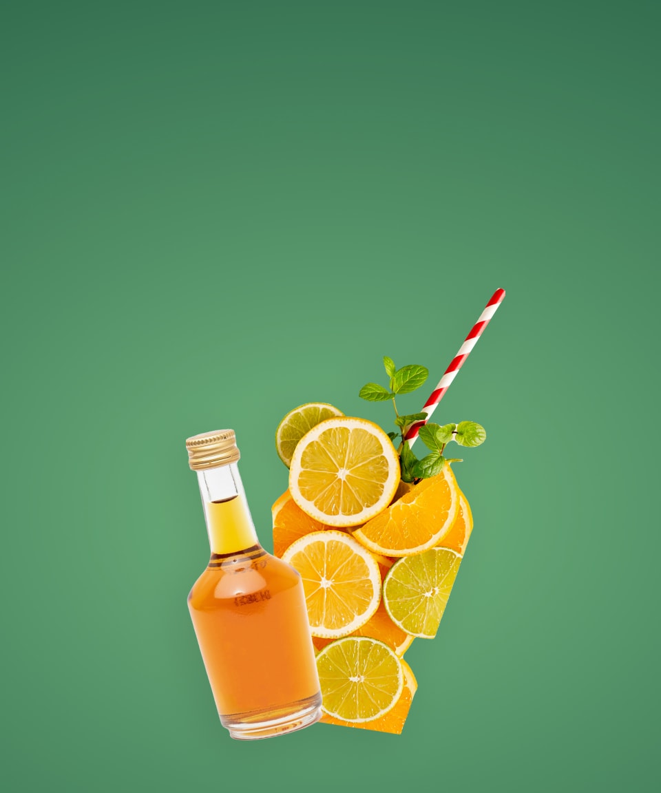 A bottle of alcohol and slices of oranges and lemons arranged in the shape of a glass with a straw and sprig of herbs for Confetti's Virtual Cocktail Box