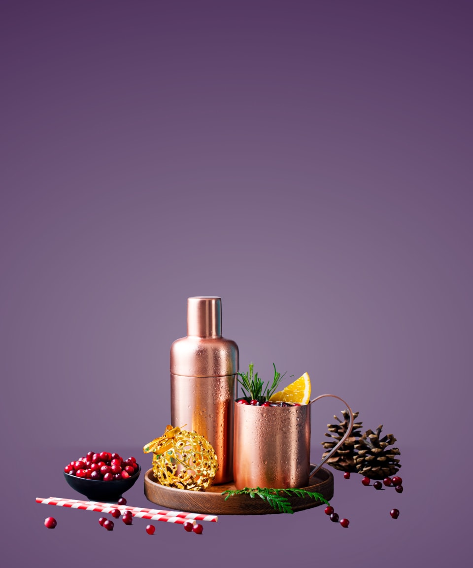 a copper cocktail shaker and copper mug with a holiday elixir surrounded by festive decorations for Confetti's Virtual Holiday Elixir Making Class