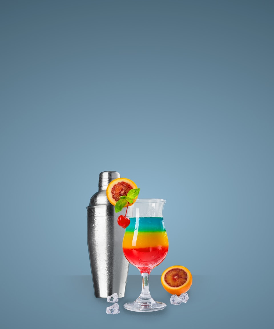 A metal shaker next to a hurricane glass with a striped rainbow cocktail inside for Confetti's Virtual Custom Mixology Class