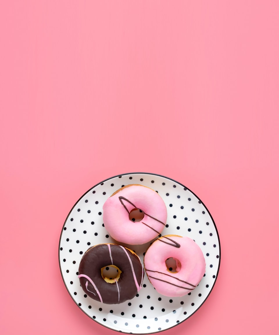 Pink and Brown frosted donuts on a plate for Confetti's Virtual Donut Making Class