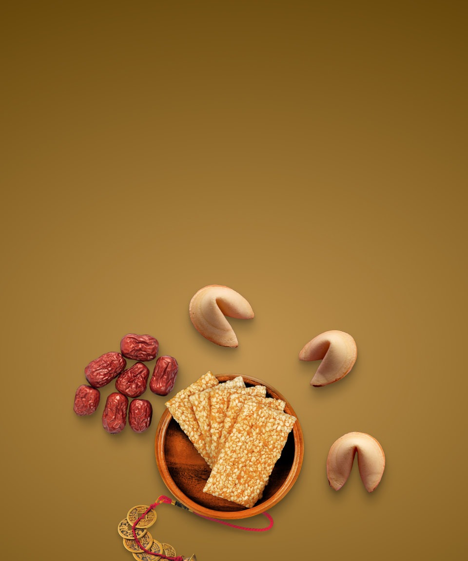 A bowl of sesame crackers next to gold coins, dates, and fortune cookies for Confetti's AAPI Mystery Snack Box