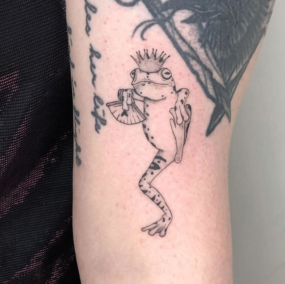 Dancing frog with crown tattoo by Brenda Mena