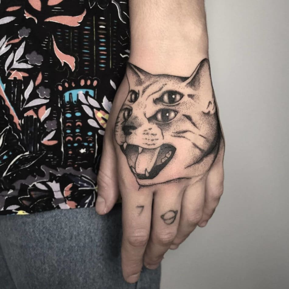 Double eyed cat tattoo on the hand by Filipa Vargas