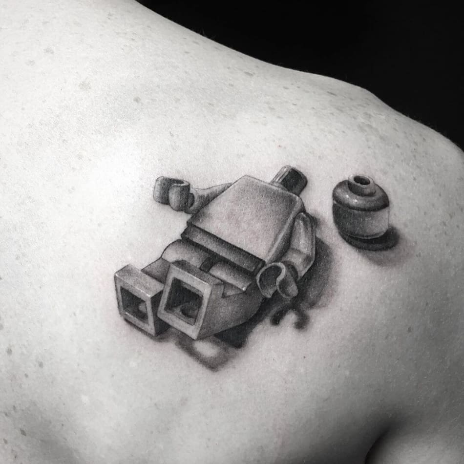 Lego figure with his head next to him tattoo