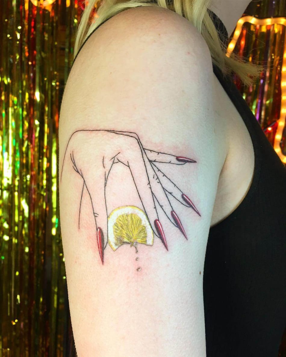 Hand squeezing a lemon tattoo by Shannon Perry