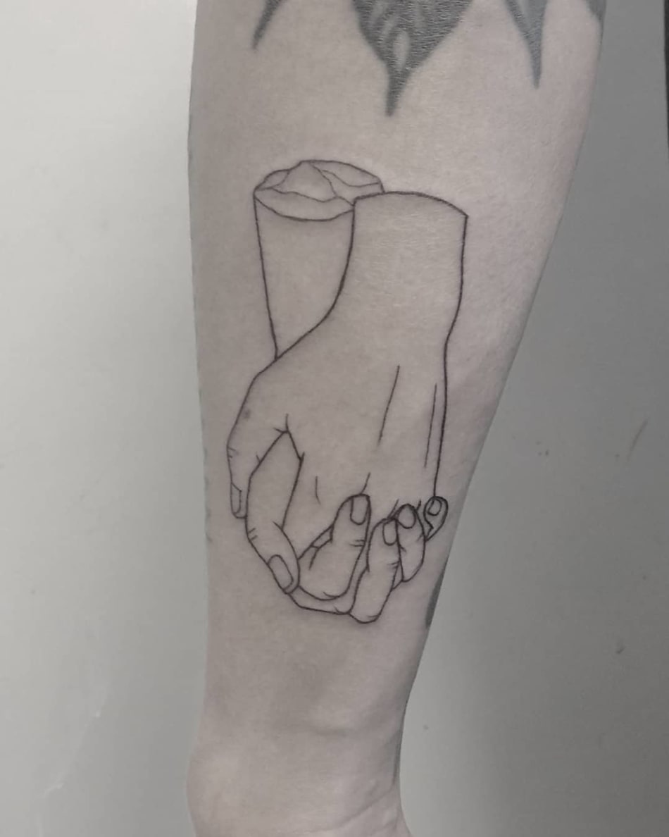 Hands holding eachother tattoo by Tattson