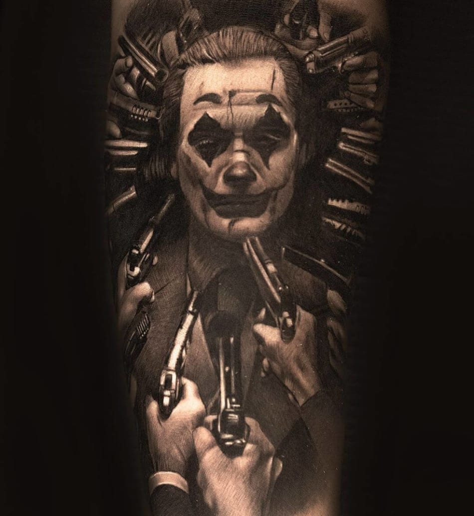 Tattoo of Joaquin Phoenix as the joker surrounded with guns to his head