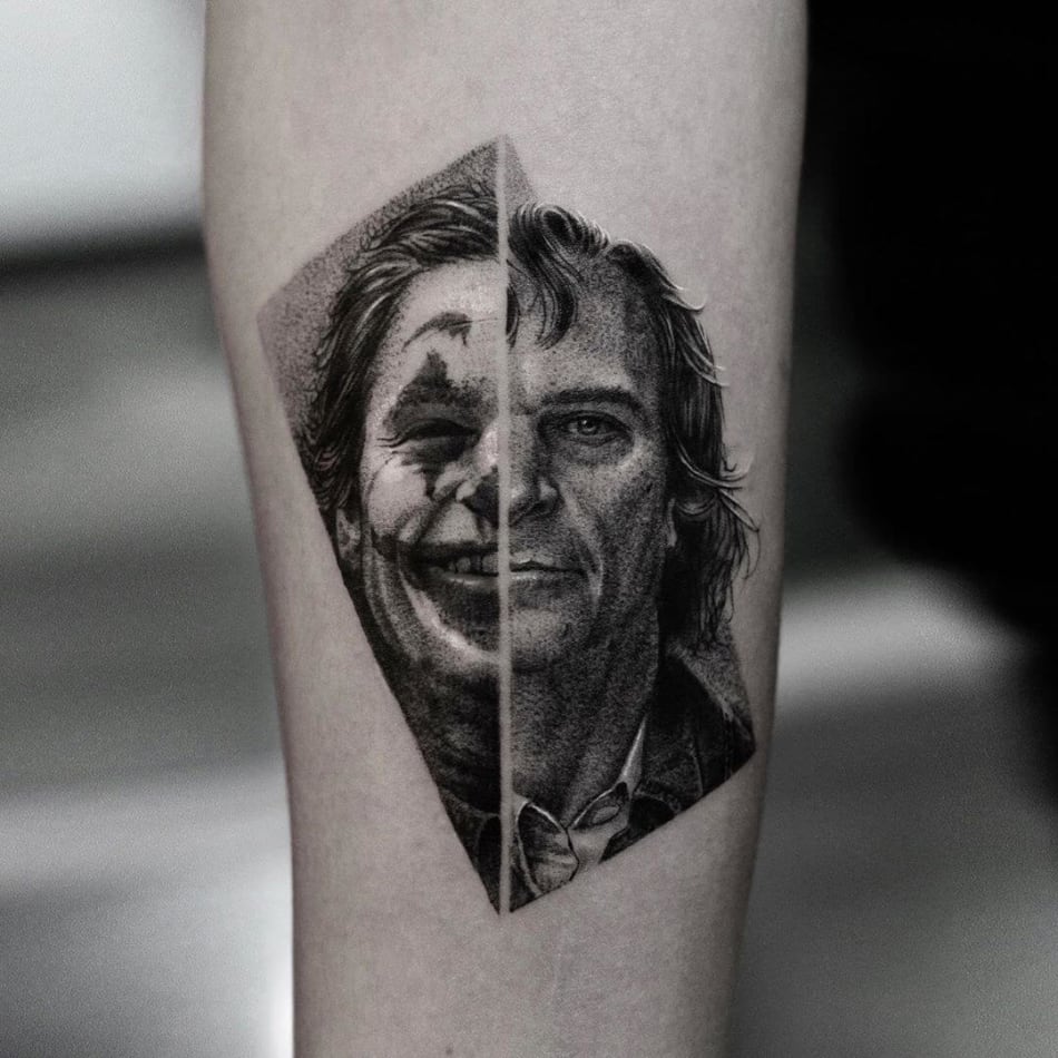 Tattoo portrait of Joaquin Phoenix where half his face is him and half his face it painted like The Joker