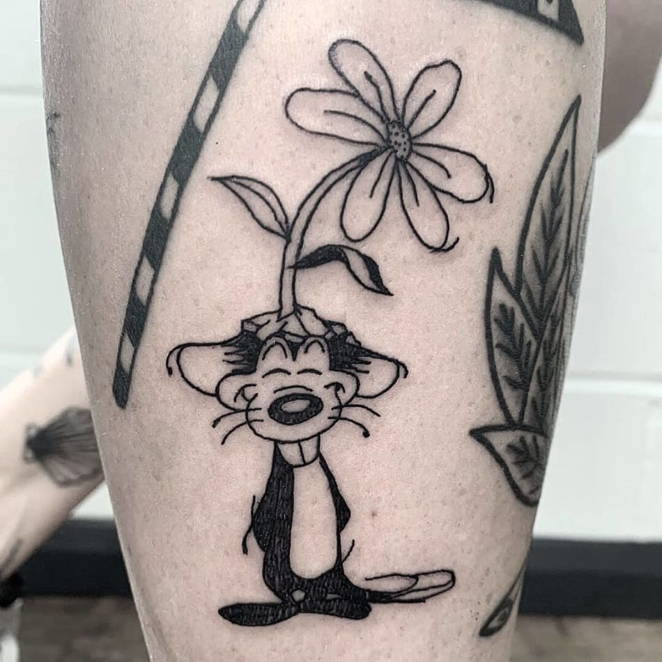 Tattoo of a cartoon mouse with a plant on his head