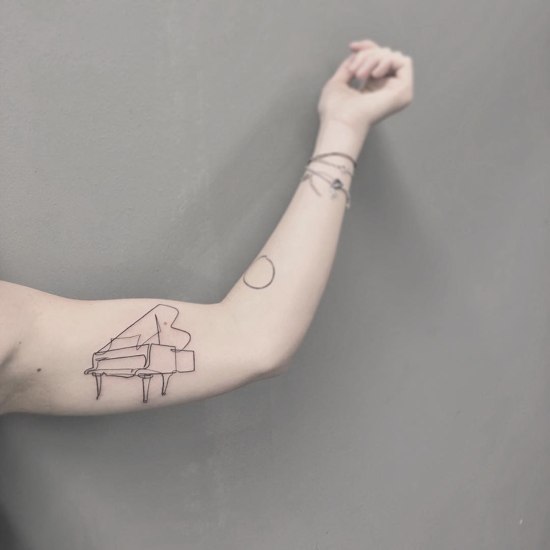 Oneline tattoo of a piano