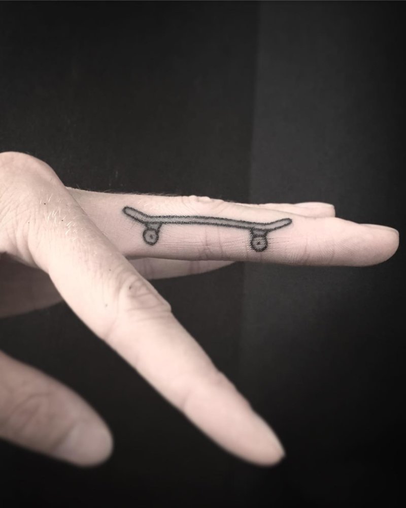 Little skateboard tattooed on a finger