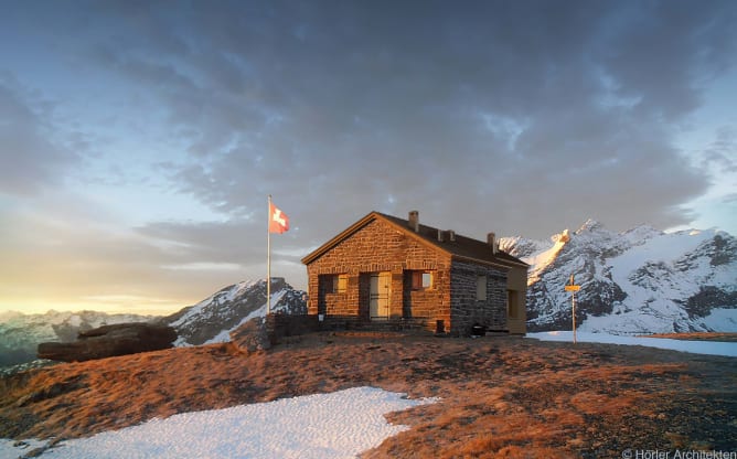 Sicht von Nordost. Für den ankommenden Hüttengast sieht die Hütte fast aus wie bisher, der Anbau ist hinten versteckt. Visualisierung © Hörler Architekten