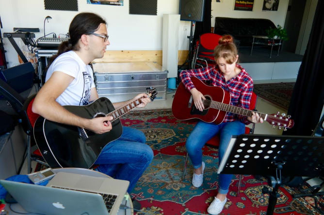 Volle Konzentration beim akustischen Gitarrenunterricht 