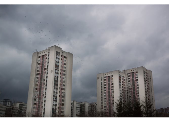 Düstere Wolken schweben. Ein Vogelschwarm nimmt seinen Abflug. Sarajevo.