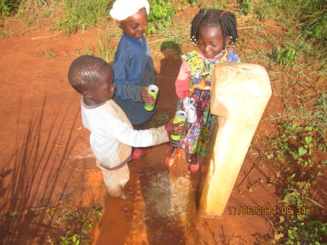 Des enfants du village buvant de l’eau de l’une des bornes fontaines du village.