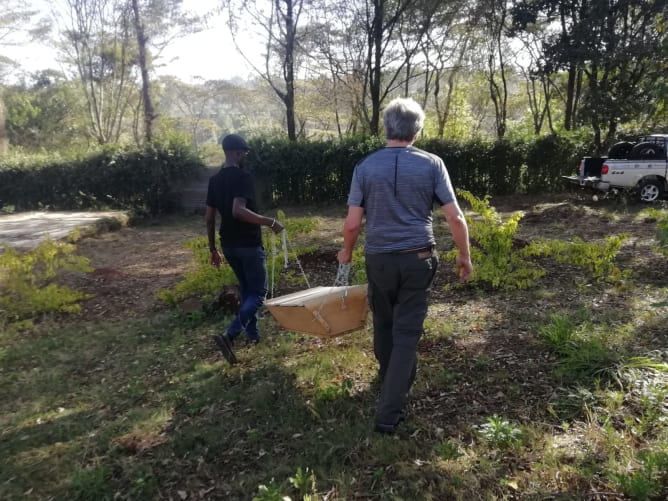 Bonny and Norbert carrying our beehive to the garden