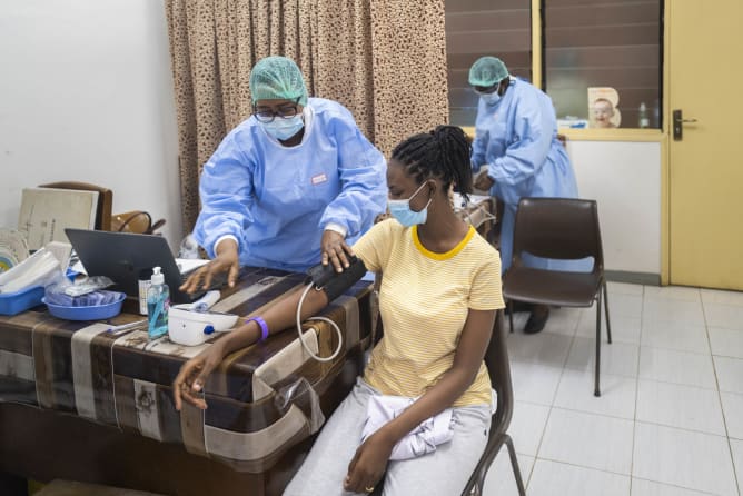 Centre de soins en Afrique, médecin qui prend la tension d'une patiente