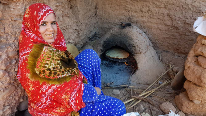 Rokya (Mitglied einer der begünstigten Familien) am traditionellen Brotbackofen