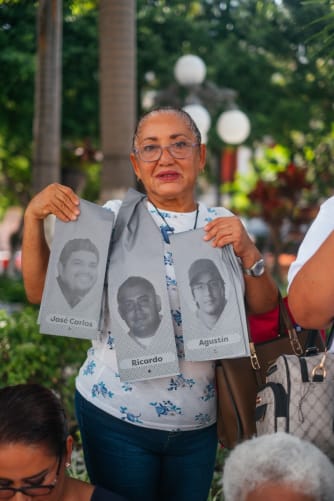 Lety, from Colectivo Solecito de Veracruz, holds the ribbon of Ricardo, her son, and of disappeared family members of her friends.