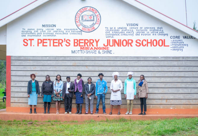Teachers and staff of the St.Peter's Berry Junior School. On the background motto and vision of the school