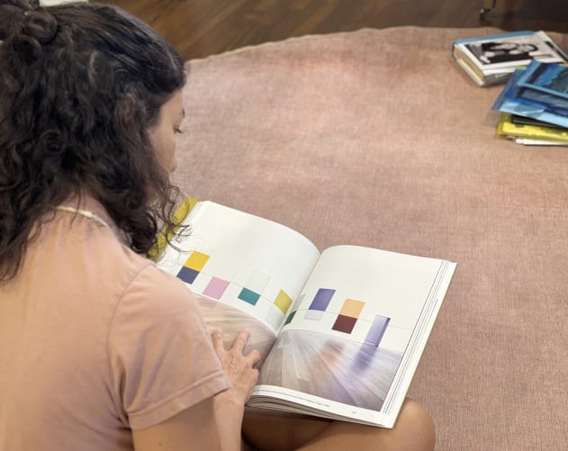 Mariana looking at Kapwani Kiwanga art book featuring her Linear Paintings (Jrp Ringier Kunstverlag Ag).