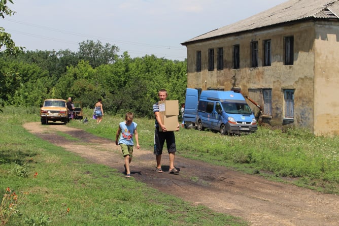 Verteilung von Hilfsgütern in Zaitsevo. Der blaue Lieferwagen ist von den schlechten Strassen stark mitgenommen und muss dringend ersetzt werden.