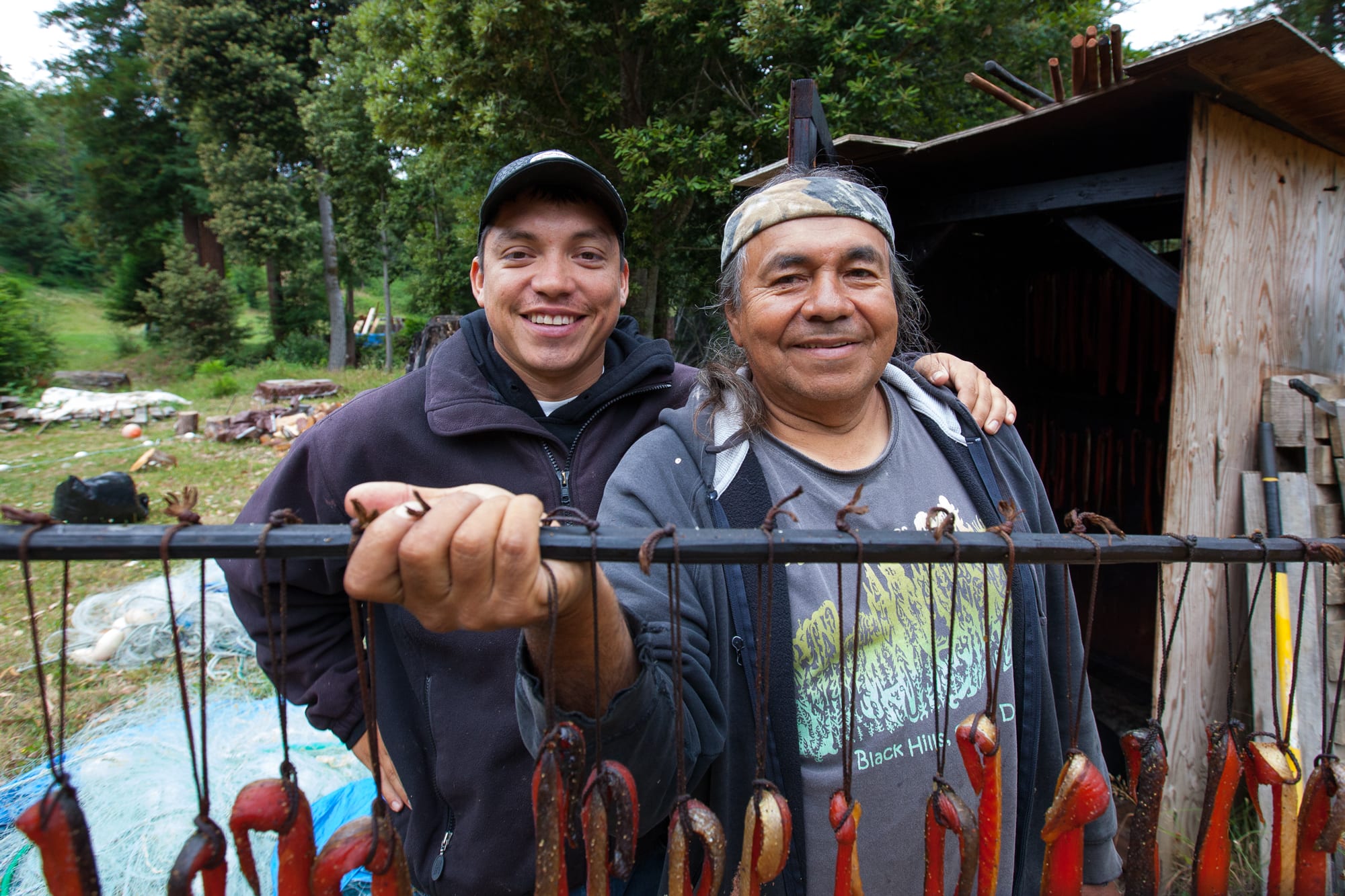 Yurok Tribe member Willard Carlson and his son Pergish Carlson smoking salmon